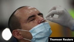 Un trabajador de la salud toma una muestra de un hombre para ser examinado por la enfermedad del coronavirus (COVID-19), en Buenos Aires, el 7 de abril de 2021.