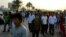 FILE - Migrant workers walk on the corniche in Doha, Qatar, April 14, 2017. 