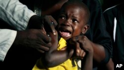 Seorang anak lakik-laki menangis saat disuntik vaksin demam kuning di distrik Kisenso, Kinshasa, Kongo, Juli 2016. (AP/Jerome Delay)