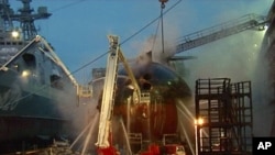 In this video image from Ru-RTR Russian state television channel, firefighters spray water on the Yekaterinburg nuclear submarine in a dock at the Roslyakovo shipyard in the Murmansk region, Russia. A fire that erupted while the Yekaterinburg was in 