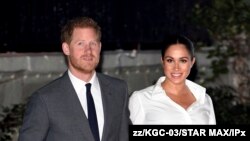 FILE - In this May 8, 2019 file photo Britain's Prince Harry and Meghan, Duchess of Sussex, pose during a photocall with their newborn son Archie, in St George's Hall at Windsor Castle, Windsor, south England. 