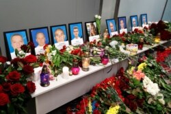 Flowers and candles are placed in front of the portraits of the flight crew members of the Ukraine International Airlines Boeing plane that crashed in Iran, at a memorial at the Boryspil International airport outside Kiev, Ukraine
