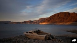 Un bote hundido se observa en un área del Lago Mead después de bajar las aguas por la sequía el 10 de mayo de 2022. Foto AP.