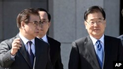 South Korea's national security director Chung Eui-yong, right, and National Intelligence Service Chief Suh Hoon, left, talk before boarding an aircraft as they leave for Pyongyang at a military airport in Seongnam, south of Seoul, March 5, 2018. 