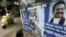 A woman rides her bike past the election posters of Sri Lanka's former Sri Lankan President Mahinda Rajapaksa for upcoming general election in Colombo, July 14, 2015.