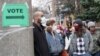 FILE - Voters masked against coronavirus line up at Riverside High School for Wisconsin's primary election, April 7, 2020, in Milwaukee. 