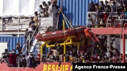 Migrants rescued in the Mediterranean sea arrive to disembark from the Sea-Eye 4 ship, Nov. 7, 2021, in the port of Trapani, Sicily, Italy. 