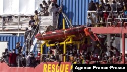 Para migran yang diselamatkan oleh kapal Jerman "Sea-Eye 4" tiba di pelabuhan Trapani, Sisilia, Italia selatan, Minggu (7/11). 