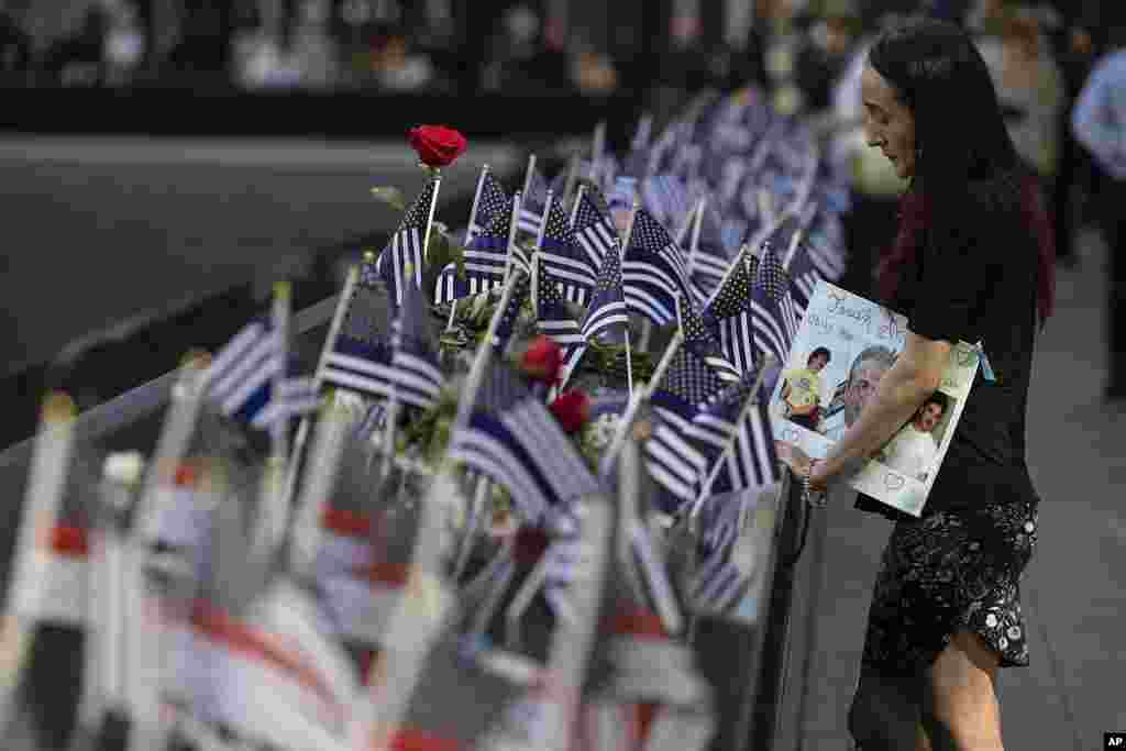Mercedes Arias stands by the name of her father Joseph Amatuccio on the south pool during the 9/11 memorial ceremony on the 23rd anniversary of the attacks, in New York, Sept. 11, 2024.