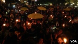 港人在六四烛光晚会上打出象征雨伞运动的黄伞要求真普选