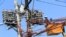 FILE - Filipino lineworkers repair power meters atop electricity post at the main street of Quiapo city, metro Manila, Philippines, Aug. 11, 2017. 