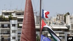 Palestinian, French and the European Union flags are seen on the mast of a French activists' boat moored in Pireaus port, near Athens, Greece, July 4, 2011