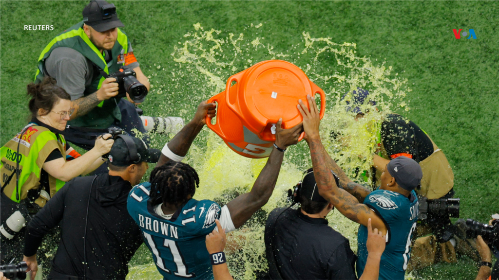 A.J. Brown e DeVonta Smith derramam Gatorade sobre o treinador Nick Sirianni durante o Super Bowl, onde a equipa de Filadélfia conquistou o título de campeão.