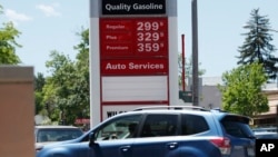 FILE - Prices for the three grades of gasoline light up the pump at a Conoco stationin east Denver, May 25, 2018.