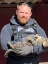 Reuters safety advisor Ryan Evans holds a cat in Niu-York