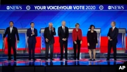 FILE - From left, Democratic presidential candidates Andrew Yang, Pete Buttigieg, Bernie Sanders, Joe Biden, Elizabeth Warren, Amy Klobuchar and Tom Steyer are seen ahead of their debate at Saint Anselm College in Manchester, New Hampshire, Feb. 7, 2020.