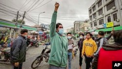 FILE - Anti-government protesters march in Mandalay, Myanmar, Dec. 7, 2021. The demonstration came a day after a special court sentenced the country’s ousted leader, Aung San Suu Kyi, to prison, finding her guilty of incitement and violating coronavirus restrictions.