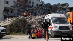 Para anggota SAR di lokasi gedung yang roboh akibat gempa kuat di Antakya, Turki, 18 Februari 2023. (Foto: Maxim Shemetov/Reuters)