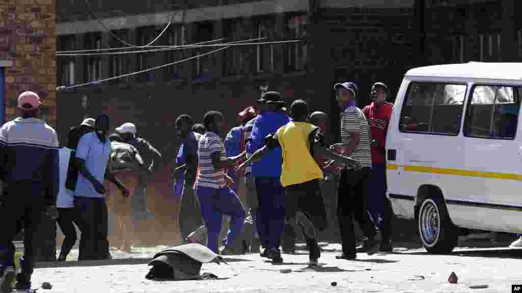 La police a tiré des balles en caoutchouc et des grenades à gaz lacrymogène pour disperser une foule de manifestants xénophobes à l&rsquo;extérieur d&#39;une auberge, à Actonville, à l&#39;est de Johannesburg, Afrique du Sud, jeudi 16 avril 2015.