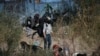 Un migrante intenta cruzar la alambrada que divide la frontera sur de Estados Unidos con México el 27 de diciembre mientras se reunían en la capital mexicana altos funcionarios de EEUU y mexicanos para discutir la situación. 