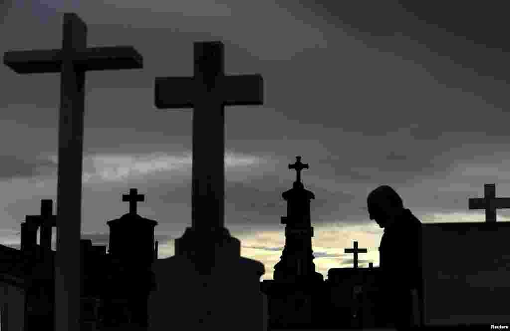 A man walks along the tombs at the municipal cemetery of San Salvador in Oviedo, northern Spain. Catholics will mark All Saints&#39; Day on Sunday by visiting cemeteries and graves of deceased relatives and friends.