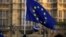FILE - A pro-Europe demonstrator holds a flag outside the Houses of Parliament in London, Jan. 8, 2019.
