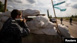 Pro-Russian separatists man a road checkpoint outside the town of Lysychansk in the Luhansk region of eastern Ukraine, June 24, 2014. 