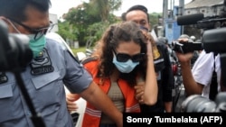 Heather Mack (tengah) digiring oleh petugas imigrasi menuju kantor imigrasi di Jimbaran, Bali, sesaat setelah dibebaskan dari penjara pada 29 Oktober 2021. (Foto: AFP/Sonny Tumbelaka)