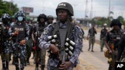 FILE - Police patrol during a protest against the economic hardship on the street in Lagos, Nigeria, Aug. 2, 2024. Nigeria Protests