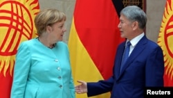 German Chancellor Angela Merkel and Kyrgyz President Almazbek Atambayev talk during their meeting in Bishkek, Kyrgyzstan, July 14, 2016.
