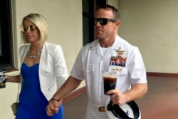 FILE - Navy SEAL Edward (Eddie) Gallagher, right, walks with his wife, Andrea Gallagher, as they arrive at a military court on Naval Base San Diego, in San Diego, California, June 26, 2019.