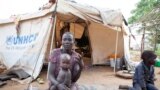 FILE - A woman and her children displaced by fighting in South Sudan sit outside her tent at the Kule camp for Internally Displaced People at the Pagak border crossing in Gambella, Ethiopia.