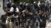 Members of Indonesian police anti-terror unit Special Detachment 88 move into positions as they prepare for a raid in Solo, Central Java, Indonesia, September 26, 2012.