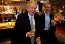 Boris Johnson, a leadership candidate for Britain's Conservative Party, and Britain's former Brexit Minister Dominic Raab visit a pub in Oxshott.