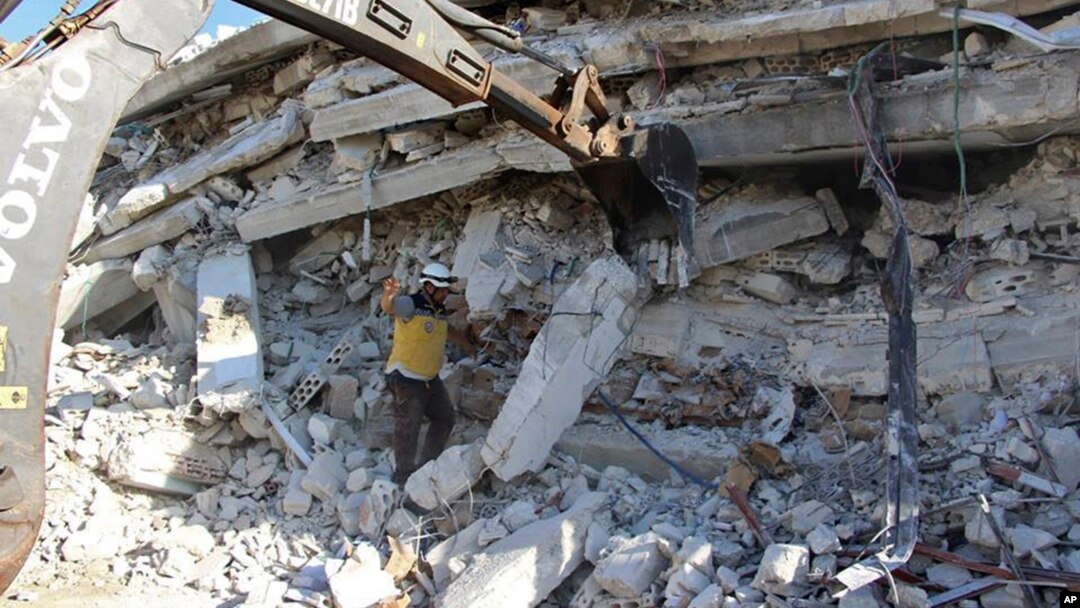 This photo provided by the Syrian Civil Defense White Helmets, which has been authenticated based on its contents and other AP reports, shows White Helmet civil defense workers after an explosion in north Syria, Aug. 12, 2018.
