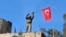 A soldier waves a Turkish flag as Turkish troops secure Bursayah hill, which separates the Kurdish-held enclave of Afrin from the Turkey-controlled town of Azaz, Syria, Jan. 28, 2018. 