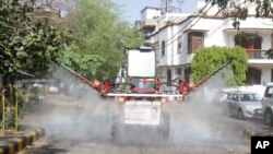A Delhi government worker sanitizes a residential area using a Japanese machinery capable of disinfecting a large area to prevent the spread of Covid-19 in New Delhi, India, April 13, 2020.