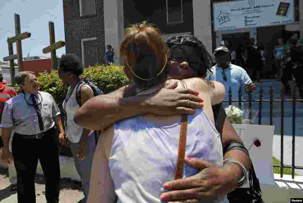 Mourners embrace outside Morris Brown AME Church before attending a vigil the day after a mass shooting in Charleston, South Carolina, June 18, 2015. 