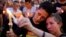 FILE - People hold candles during a vigil downtown for the victims of a mass shooting at the Pulse nightclub in Orlando, Florida, June 13, 2016.