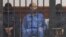 Saif al-Islam Gadhafi in the accused cell as he stands trial for illegally trying communicating with the outside world in June of 2012, Zintan, Libya, May 2, 2013.
