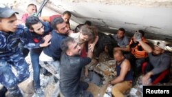 Rescuers carry Suzy Eshkuntana, 6, as they pull her from the rubble of a building at the site of Israeli air strikes, in Gaza City May 16, 2021. The pre-dawn Israeli strike killed her mother and all four of her siblings.