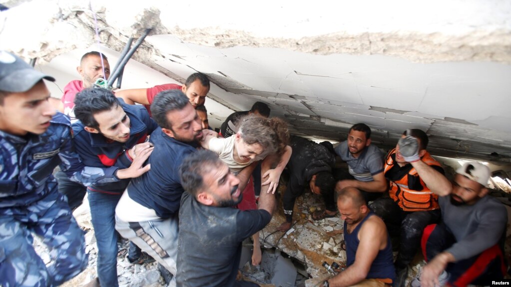 救援人员从一处空袭废墟中抢救出一名六岁的女童。(photo:VOA)