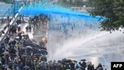 Para pengunjuk rasa pro-demokrasi bereaksi ketika polisi menembakkan meriam air di luar markas pemerintah di Hong Kong pada 15 September 2019. (Foto: AFP)