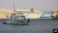 Sebuah kapal kargo meluncur di Terusan Suez, setelah lalu lintas pelayaran kapal-kapal yang sebelumnya macet berhasil dipulihkan kembali (foto: dok). 