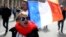 A far-right supporter marches next to French flag near the statue of Joan of Arc for his traditional march, May 1, 2017, in Paris. 