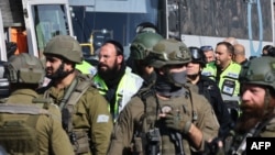 Israeli rescuers and security forces work at the site of an attack near the village of al-Funduq, in the occupied West Bank, on January 6, 2025.