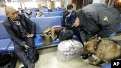 A police officer with a sniffer dog checks a passenger's luggage at the Yemelyanovo airport near Russia's Siberian city of Krasnoyarsk, Jan 26, 2011