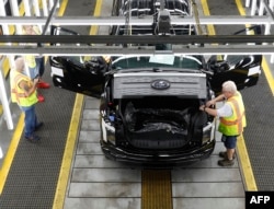 FILES - Ford Motor Co. battery powered F-150 Lightning trucks under production at their Rouge Electric Vehicle Center in Dearborn, Michigan on September 20, 2022. (Photo by JEFF KOWALSKY / AFP)