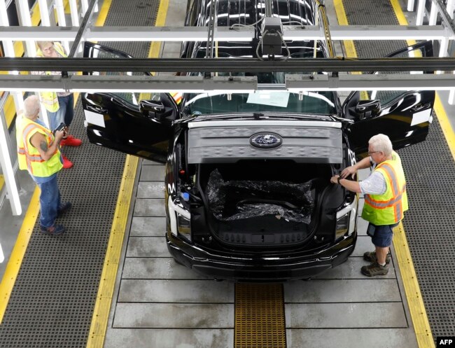 FILES - Ford Motor Co. battery powered F-150 Lightning trucks under production at their Rouge Electric Vehicle Center in Dearborn, Michigan on September 20, 2022. (Photo by JEFF KOWALSKY / AFP)