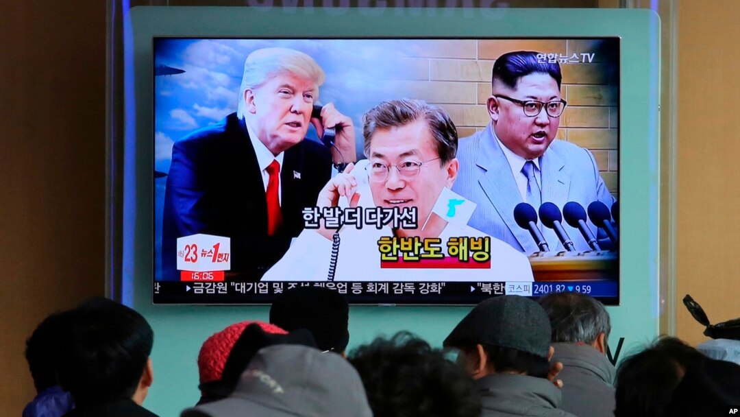 Para pengunjung stasiun kereta Seoul di Korea Selatan menyaksikan penayangan berita yang menampilkan gambar pemimpin Korea Utara Kim Jong-un (kanan), Presiden Korea Selatan, Moon Jae-in (tengah) dan Presiden AS Donald Trump, 7 Maret 2018. (Foto: dok). 